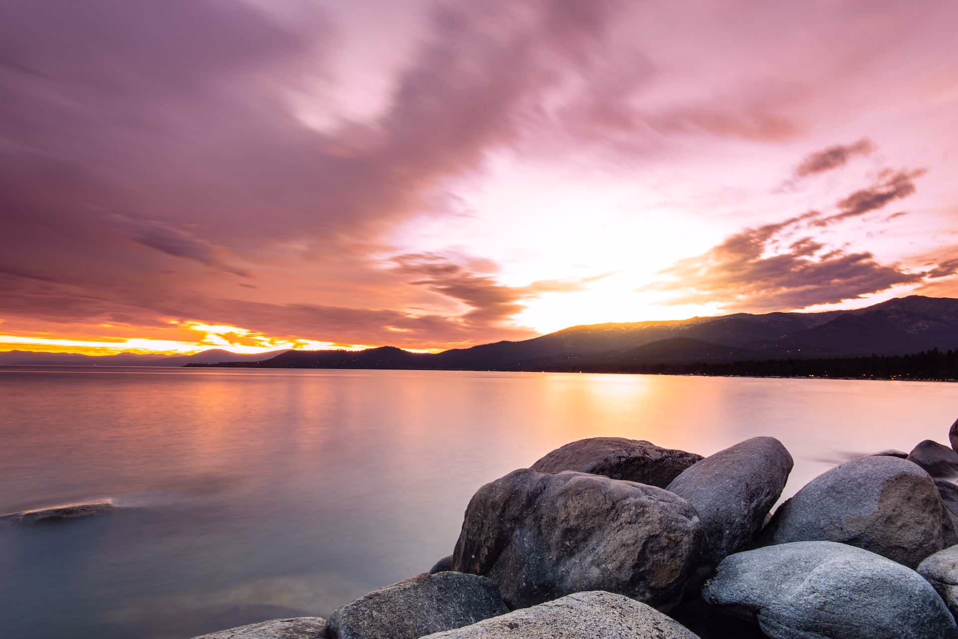 Dramatic sunset boudoir portrait on rocks at South Lake Tahoe